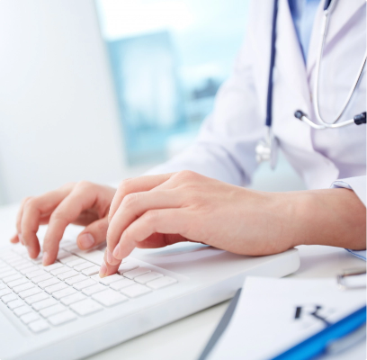 person typing on a white keyboard in doctor scrubs